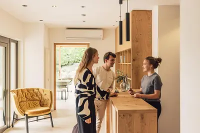 a group of people standing in a kitchen at Pomella's Guesthouse in Cortaccia