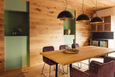a dining room with a wooden table and chairs at Pomella's Guesthouse in Cortaccia