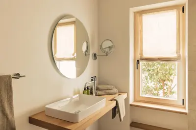 a bathroom with a white sink and a mirror at Pomella's Guesthouse in Cortaccia