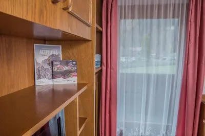 a bedroom with a bed and a tv and curtains at Apartment - Alpin Chalet Frenademetz in San Martino in Badia