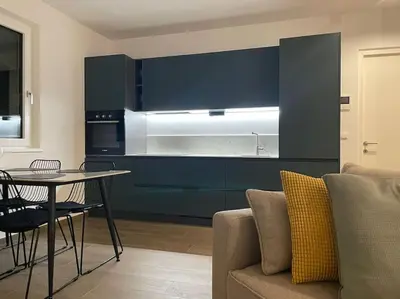a kitchen with blue cabinets and a table and a couch at Terrazza Palade in Merano