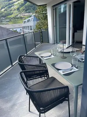 a table and chairs sitting on a balcony with a table and chairs at Terrazza Palade in Merano