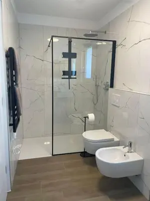 a bathroom with a shower and a toilet and a sink at Terrazza Palade in Merano