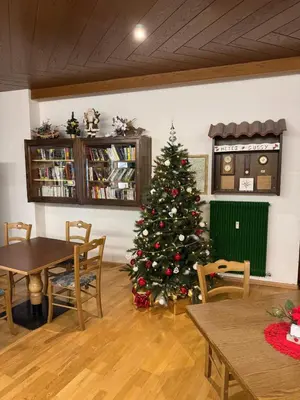 a christmas tree in a room with a table and chairs at Casa Serenity in Falcade
