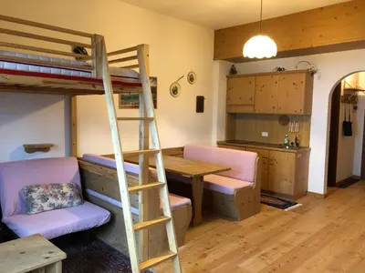 a room with a bunk bed and a table and a desk at Casa Serenity in Falcade