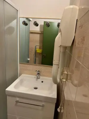 a bathroom with a sink and a phone next to a mirror at Casa Serenity in Falcade