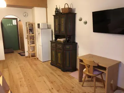 a room with a table and a cabinet and a refrigerator at Casa Serenity in Falcade