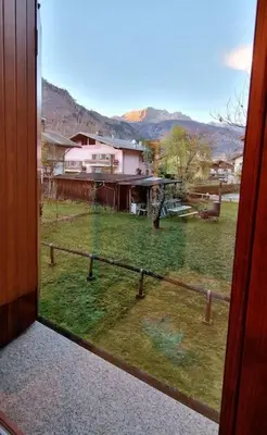 a view of a yard from a window of a house at trilocale panorama val di fiemme in Predazzo