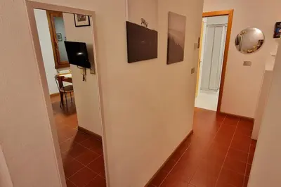 a hallway with a wall with a television on it at trilocale panorama val di fiemme in Predazzo