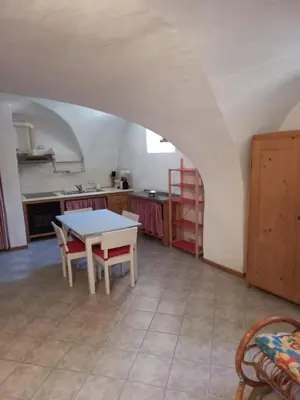 a kitchen with a table and chairs in a room at Ala Roda- appartamento in Ziano di Fiemme