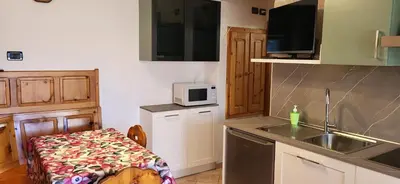 a small kitchen with a sink and a microwave at Casa Clo' in Varena