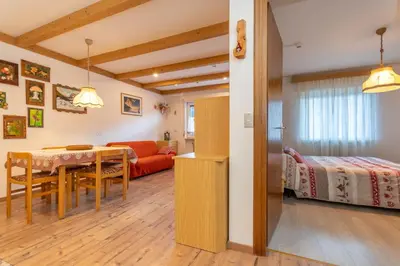 a room with a dining table and a bedroom at Appartamento Lucia 201 in Vigo di Fassa