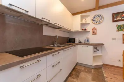a kitchen with white cabinets and a sink at Appartamento Lucia 201 in Vigo di Fassa