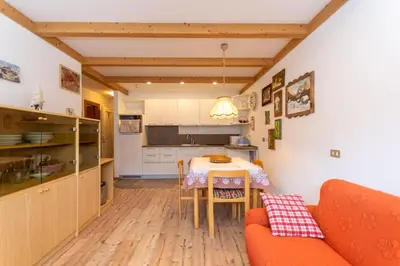 a kitchen and dining room with a table and a couch at Appartamento Lucia 201 in Vigo di Fassa