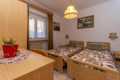 a bedroom with two beds and a table at Appartamento Lucia 201 in Vigo di Fassa