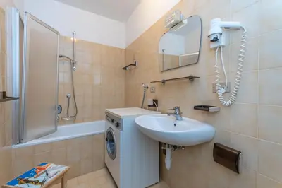 a bathroom with a sink and a washing machine at Appartamento Lucia 201 in Vigo di Fassa