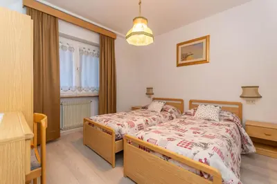 a bedroom with a bed and a window at Appartamento Lucia 203 in Vigo di Fassa