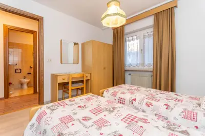 a bedroom with a bed and a bathroom at Appartamento Lucia 203 in Vigo di Fassa