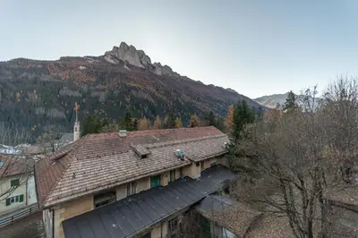 a building with a mountain in the background at Appartamento Lucia 203 in Vigo di Fassa