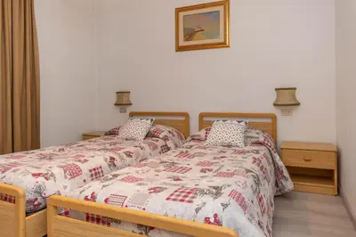 two beds sitting next to each other in a bedroom at Appartamento Lucia 203 in Vigo di Fassa