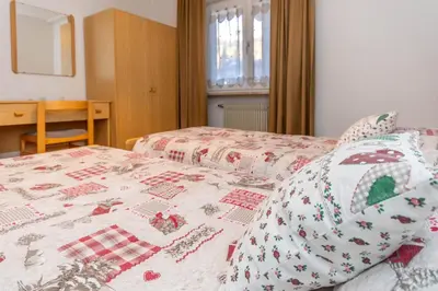 a bedroom with a bed with a quilt on it at Appartamento Lucia 203 in Vigo di Fassa