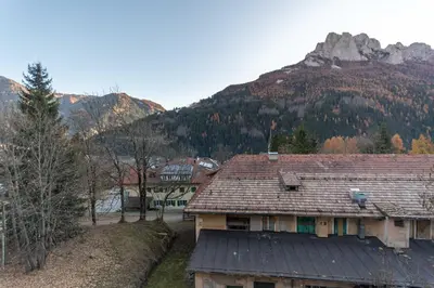 a house in the foreground with a mountain in the background at Appartamento Lucia 203 in Vigo di Fassa