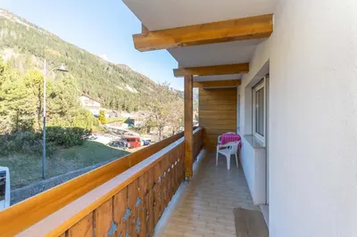 a balcony with a table and a chair on it at Appartamento Alessandra 106 in Vigo di Fassa