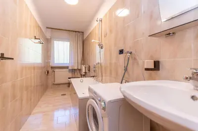 a bathroom with a washing machine and a sink at Appartamento Alessandra 106 in Vigo di Fassa