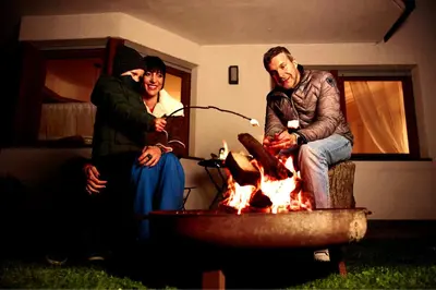 a group of people sitting around a fire pit at Stadtnestl Apartment in Vipiteno