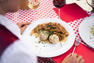 a person sitting at a table with a plate of food at Stadtnestl Apartment in Vipiteno