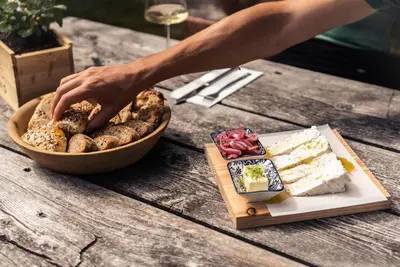 a person reaching for a plate of food on a table at Stadtnestl Apartment in Vipiteno