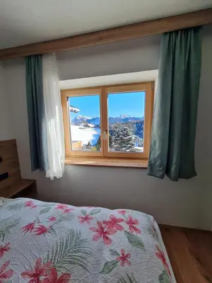 a bedroom with a bed and a window at Ciasa Sabine in Antermoia