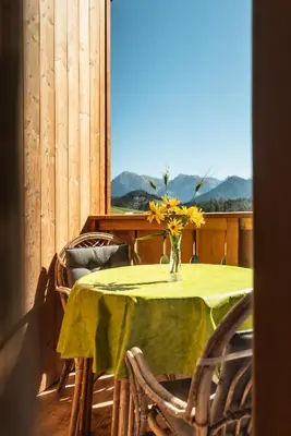 a table with a vase of yellow flowers on it at Ciasa Sabine in Antermoia