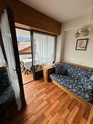 a living room with a couch and a large window at Appartamento da Zambon in San Vito di Cadore