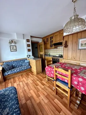 a kitchen with a table and a couch in a room at Appartamento da Zambon in San Vito di Cadore