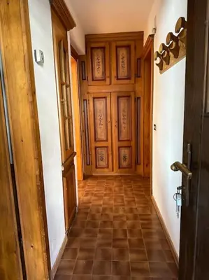 a hallway with a wooden door and a tiled floor at Appartamento da Zambon in San Vito di Cadore