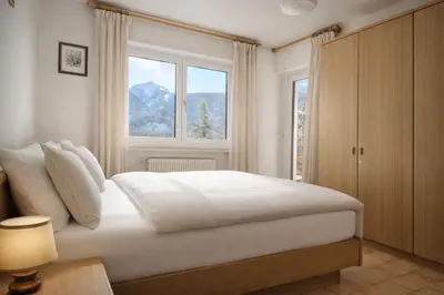 a bedroom with a large bed and a window at La casa sul giardino in Castello di Fiemme