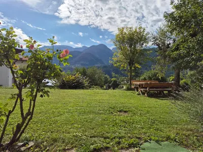 a park with a bench and a picnic table at La casa sul giardino in Castello di Fiemme