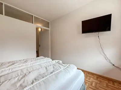 a bedroom with a bed and a flat screen tv on the wall at Chalet Vernel in Canazei