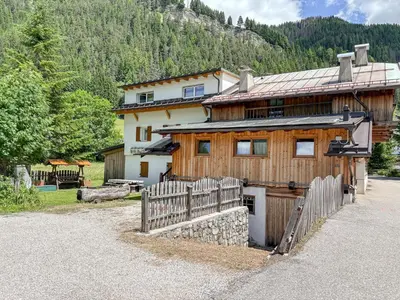 a large wooden house with a fence in front of it at Chalet Vernel in Canazei