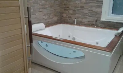 a white bath tub in a bathroom with a window at Azalea in Canazei