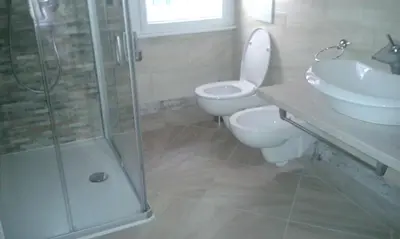 a bathroom with a toilet and a sink and a shower at Azalea in Canazei