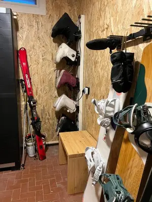 a room with a wall with a bunch of ski equipment at Appartamento Le Due Cime a Pozza di Fassa TRENTO in Pozza di Fassa