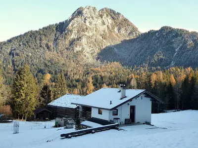 a house in the snow in front of a mountain at Baita Mountain View Pale San Martino in Fiera di Primiero