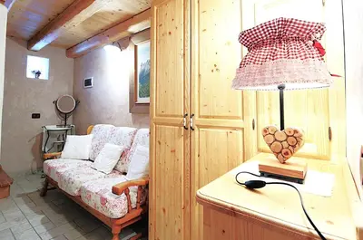 a living room with a couch and a lamp on a table at Baita Mountain View Pale San Martino in Fiera di Primiero
