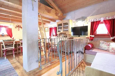 a living room with a couch and a dining room at Baita Mountain View Pale San Martino in Fiera di Primiero
