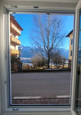 a window view of a street with a tree at Appartamento Casa AleF - L'affaccio sul Lagorai in Daiano