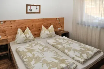 a bedroom with a large bed with two pillows at Grasspeintenhof Reiterhof in Falzes