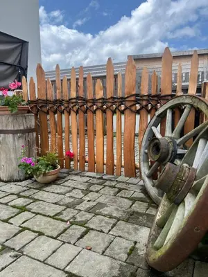 a wooden fence with a woodenoked wheel in front of a patio at Grasspeintenhof Reiterhof in Falzes