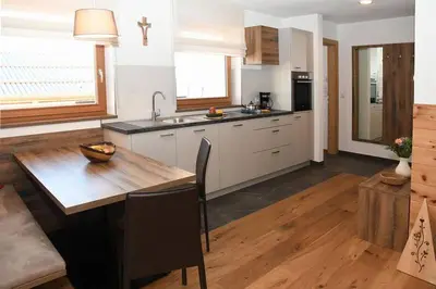 a kitchen with a wooden table and a wooden floor at Grasspeintenhof Reiterhof in Falzes